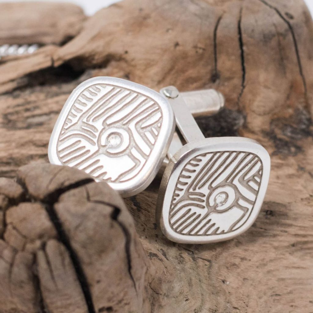 Prehistoric rock art, Isle of Doagh sterling silver cufflinks on stone background